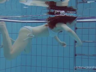 Floating bukuri në the i ngrohtë pishinë duke lakuriq